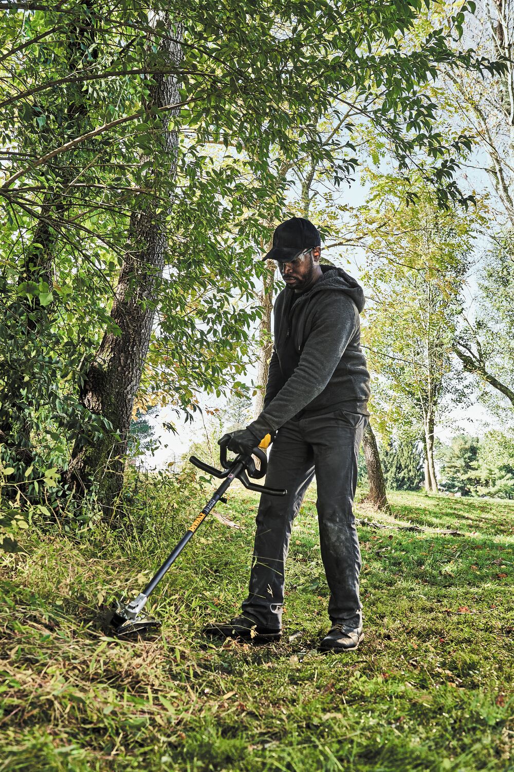 Brushless Attachment String Trimmer being used by a person outside.