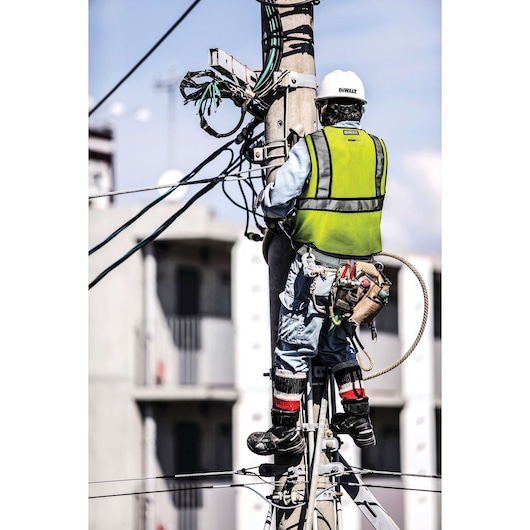 DEWALT class 2 FR mesh vest with contrasting trim being worn by a person working on electrical lines on a pole.